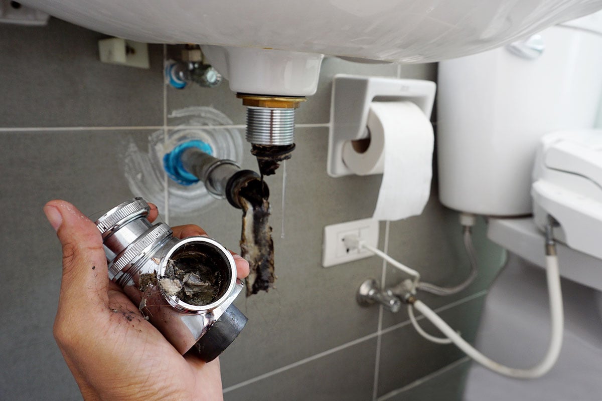 A clogged drain under a bathroom sink.
